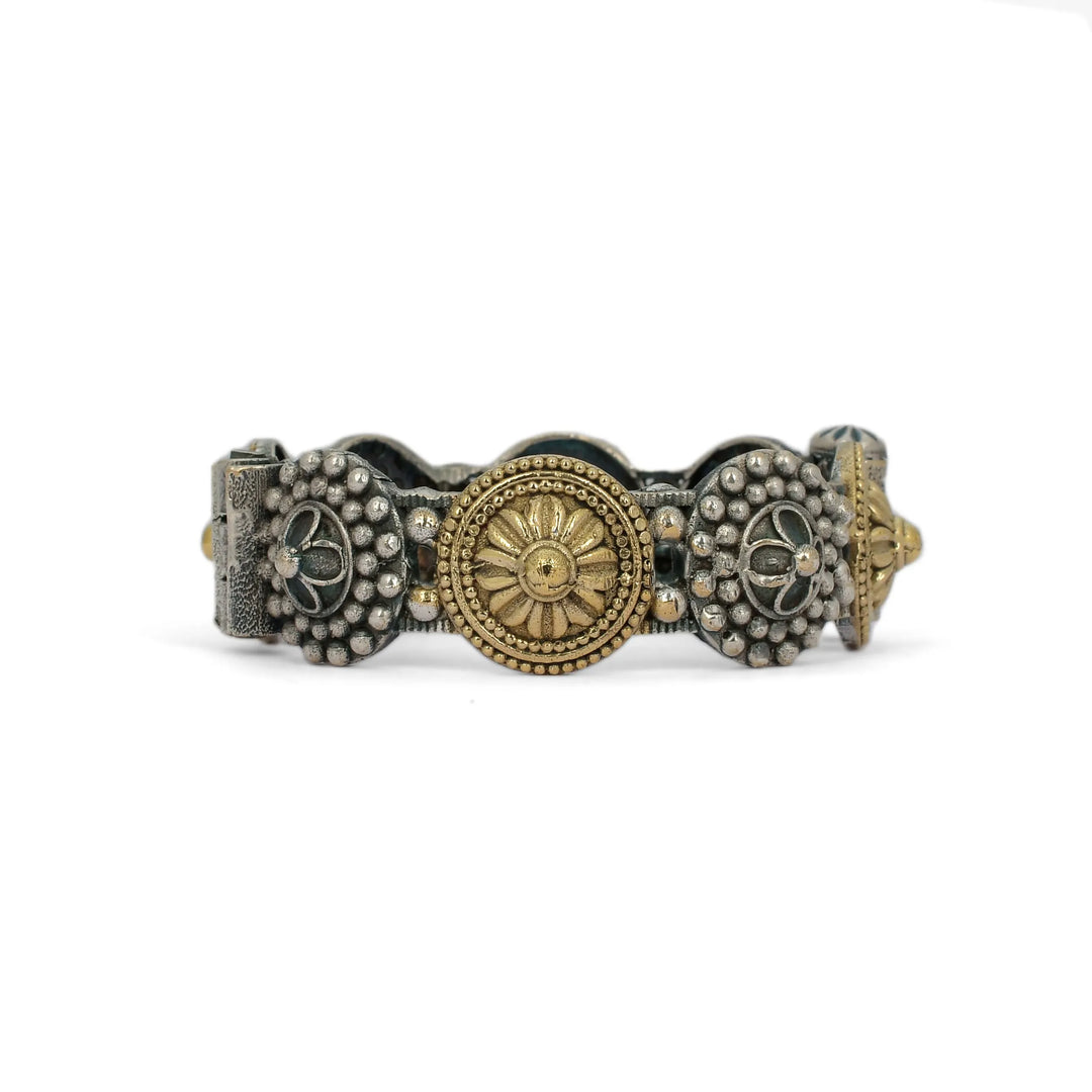 Decorative bracelet with gold and silver elements on a white background