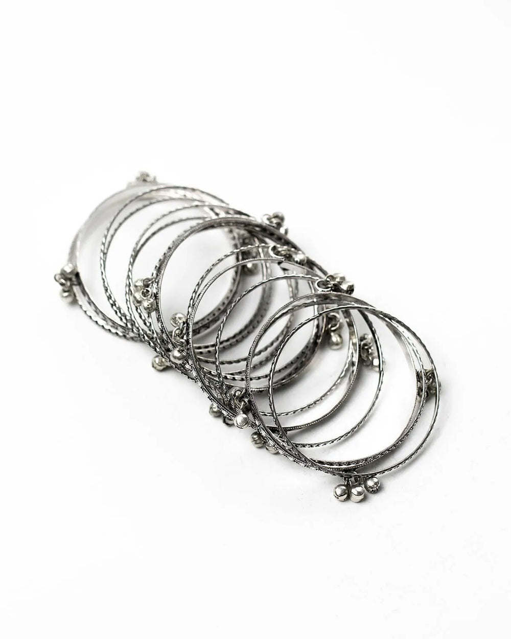 Set of silver bangles on a white background