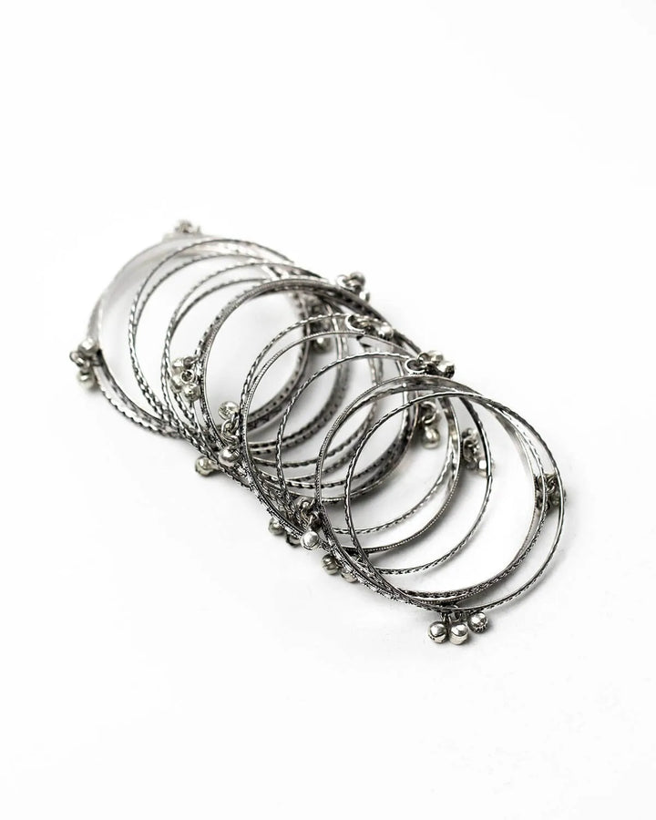 Set of silver bangles on a white background