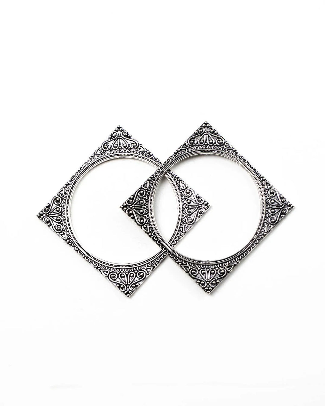Pair of square oxidised silver bangles with intricate designs on a white background